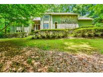 Charming two-story home with stone accents and a beautifully landscaped front yard in a serene, wooded setting at 8120 Ball Mill Rd, Atlanta, GA 30350