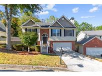 Charming two-story home with brick accents, a well-manicured lawn, and an attached two-car garage at 2140 Wildcat Cliff Ln, Lawrenceville, GA 30043