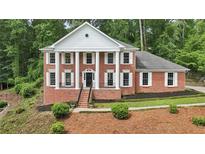 Stately brick home featuring a columned facade, manicured landscaping, and a welcoming front entrance at 5276 Beechwood Ct, Marietta, GA 30068