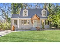 Charming home featuring a landscaped front yard and inviting light-blue front door beneath a wooden awning at 1824 Westwood Sw Ave, Atlanta, GA 30310