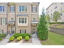 Attractive townhome featuring a well-maintained front lawn, traditional windows, and classic shutters at 4000 Chastain Preserve Ne Way, Atlanta, GA 30342