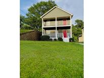 Charming two-story home featuring double porches, lush lawn, and a red front door at 2650 Batavia St, East Point, GA 30344