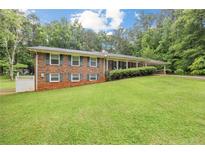 Charming brick home with well-manicured lawn, lush trees, and cozy curb appeal at 695 Hiram Sudie Rd, Dallas, GA 30157