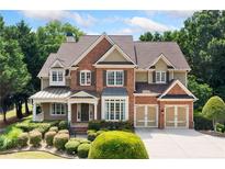 Charming two-story brick home featuring manicured landscaping and a two-car garage at 1415 Liberty Ln, Cumming, GA 30040