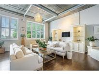 Bright, open living space with exposed pipes, hardwood floors, and large windows allowing natural light to flood in at 3235 Roswell Ne Rd # 402, Atlanta, GA 30305