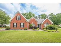 Charming brick home with a lush green lawn and manicured landscaping at 2870 Jay Oak Dr, Dacula, GA 30019