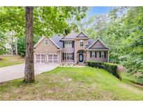 Charming two-story home with a stone and siding exterior, two-car garage, and well-manicured lawn and mature landscaping at 1058 Magnolia Dr, Villa Rica, GA 30180