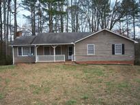 Cozy home with a welcoming front porch and mature trees in a private, wooded setting at 157 Sequoyah Cir, Canton, GA 30115