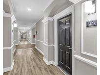 Long hallway with wood floors and neutral walls leading to the apartment entrance at 1850 Cotillion Dr # 3123, Atlanta, GA 30338