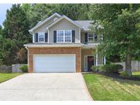 Charming two-story home featuring a two-car garage, stone accents, black shutters, and a well-manicured lawn at 112 Lexington Parke Dr, Woodstock, GA 30189