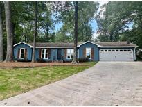 Charming blue home with beautiful wood shutters, large front lawn and wide driveway at 1743 Moss Dr, Snellville, GA 30078