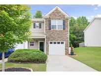 Charming townhome features a stone facade and a one-car garage with a well-manicured lawn at 257 Ridge Mill Dr, Acworth, GA 30102