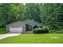 Ranch style home with mature trees and a well-manicured lawn with a two car garage at 4766 Jamerson Forest Cir, Marietta, GA 30066