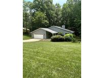 Charming single-story home featuring an attached garage, well-maintained lawn, and mature trees at 4766 Jamerson Forest Cir, Marietta, GA 30066