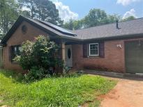 Cozy brick home featuring a charming front porch and solar panels at 1130 Monfort Rd, Lawrenceville, GA 30046