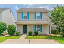 Charming two-story home featuring vinyl siding, bright blue shutters, and a well-maintained front yard at 256 Turnstone Rd, Stockbridge, GA 30281