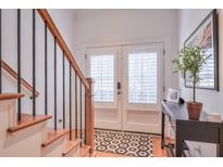 Bright foyer with staircase, console table, and beautiful double doors with modern hardware and coverings at 235 Founders Mill Ct, Roswell, GA 30075