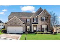 Charming two-story brick home with a well-manicured lawn and two car garage at 2468 Cannon Farm Ln, Duluth, GA 30097