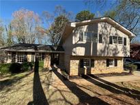 Charming two-story home featuring a brick facade, complemented by mature trees and a well-manicured front yard at 3937 Locklear Way, Atlanta, GA 30360