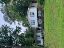 Charming home featuring white siding, blue shutters, and lush green lawn surrounded by mature trees at 2505 King Louis Rd, Conyers, GA 30012