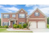 Charming two-story brick home with a two-car garage and well-manicured landscaping at 403 Sonja Ln, Loganville, GA 30052