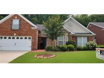 Charming single-Gathering home featuring manicured landscaping, a well-kept lawn, and a brick and stone facade at 999 Simonton Glen Dr, Lawrenceville, GA 30045