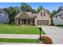 Charming single-Gathering home with a manicured lawn and inviting columned front porch at 2059 Ivey Chase Dr, Dacula, GA 30019