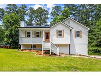 Charming renovated home with a bright exterior, inviting porch, and manicured lawn in a lush, green setting at 4430 Lamar Dr, Douglasville, GA 30134