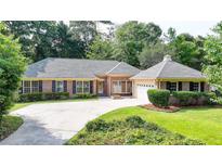 A charming single-story brick home with well-manicured landscaping, a large driveway, and a welcoming facade at 1758 N Springs Dr, Atlanta, GA 30338