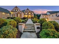 Elegant home featuring manicured landscaping, stone accents, and inviting walkway leading to the front entrance at 2377 Kesgrove Way, Buford, GA 30518