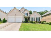 Charming two-story home featuring a well-manicured lawn and a two-car garage at 5365 Twin Creeks Dr, Norcross, GA 30071