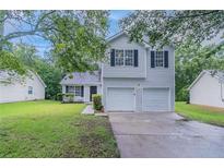 Charming two-story home with a well-maintained lawn and a two-car garage, offering curb appeal and convenience at 5421 Salem Springs Dr, Lithonia, GA 30038