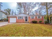 Charming brick home with a manicured lawn and a welcoming front entrance at 1410 Willow Dr, Riverdale, GA 30296