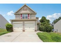 Charming two-story home with vinyl siding, a two-car garage, and manicured lawn at 7099 Skippingstone Way, Douglasville, GA 30134