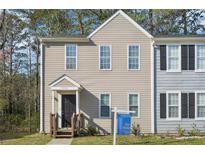 Inviting townhouse with neutral siding, a small porch, and well-maintained front yard at 7099 Skippingstone Way, Douglasville, GA 30134