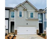 Charming townhome featuring a two-car garage and neutral siding with decorative shutters at 776 Woodstock Grove Dr, Woodstock, GA 30188