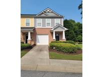 Charming townhome with colorful siding, brick accents, and a convenient one-car garage at 803 Arbor Gate Ln, Lawrenceville, GA 30044