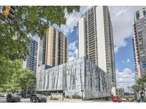 Modern high-rise building featuring glass facade and urban landscaping with tree line at 1280 W Peachtree Nw St # 3514, Atlanta, GA 30309