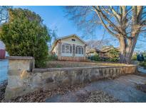 Charming bungalow with a stone wall, complemented by mature trees and a well-manicured yard at 1453 Graham Sw St, Atlanta, GA 30310