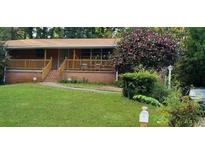 Charming brick home with a well-maintained lawn, a cozy porch, and mature landscaping at 1723 Fort Valley Sw Dr, Atlanta, GA 30311