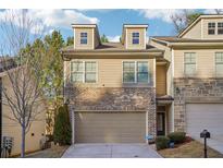 Charming townhome with a two-car garage and a mix of brick and siding exterior at 426 Mulberry Se Row, Atlanta, GA 30354