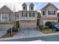 Charming townhome with neutral siding, brick accents, two-car garage, and manicured landscaping at 5008 Whiteoak Pointe Se # 15, Smyrna, GA 30080