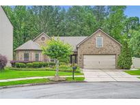 Charming brick home featuring a well-manicured lawn and a two-car garage at 1873 Jameson Cir, Lawrenceville, GA 30043