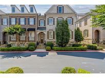 Charming townhome featuring a brick facade, manicured landscaping, and inviting curb appeal at 2362 Saint Davids Nw Sq, Kennesaw, GA 30152