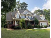 Charming two-story home with brick accents, manicured lawn, and attached garage at 2474 Starfire Ln, Loganville, GA 30052