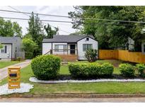 Charming home boasts a beautiful yard with manicured shrubs, a newly painted exterior, and a cozy front porch at 2736 Joyce Ave, Decatur, GA 30032