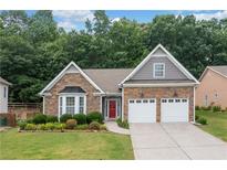 Charming single Gathering home featuring a stone facade, a bright red front door, and an attached two-car garage at 607 Little Shoals Ct, Canton, GA 30115
