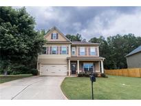 Charming two-story home featuring a manicured lawn, a two-car garage, and a welcoming front porch at , Dallas, GA 30157