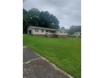 Charming ranch-style home with a spacious lawn, attached garage, and inviting front entrance with stairs at 204 Melanie Ln, Woodstock, GA 30188