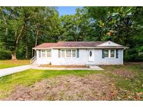 Charming one-story home with light gray brick, green shutters, and a well-manicured lawn at 10149 Puckett Sw St, Covington, GA 30014